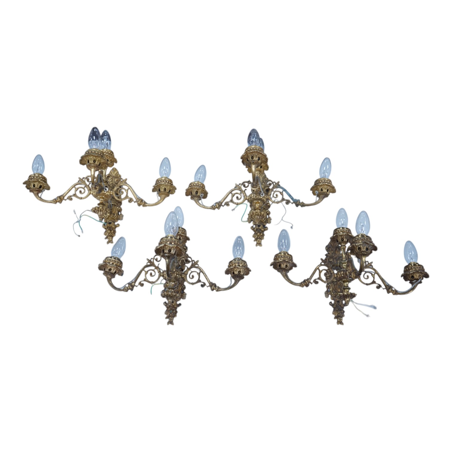 A set of four Baroque style, three branch brass wall lights. 44cm wide x 28cm high. Condition - good